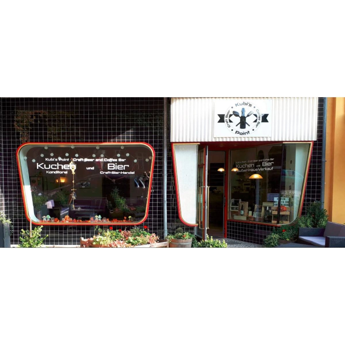 Ladenfront der Craft Beer Bar „Kubi's Point“ mit Eingangstür, Fenstern und angebrachtem Logo über dem Eingang.