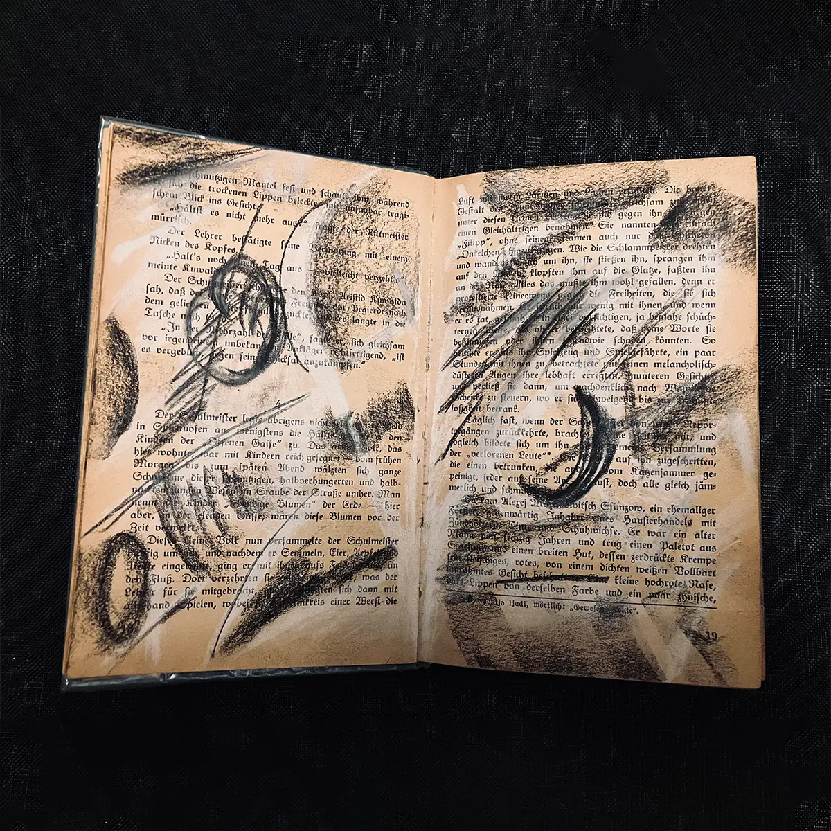 Doppelseite eines Skizzenbuchs auf bräunlichem Papier mit altdeutscher Schrift, gestaltet mit Kohle und Kreide in Schwarz, Grau und Weiß.